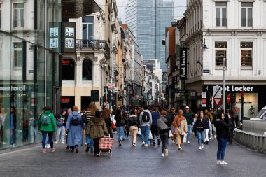 Brussels, Belgium - September 19, 2022: The dense crowd moves in both directions along the Rue Neuve shopping street. There are many shop signs on both sides of the pedestrian zone on the buildings