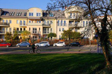 Warsaw, Poland - November 6, 2022: Cars were parked along the multi-family buildings. On the other side of the street there is a sidewalk and a path for bicycles, here in the Goclaw estate