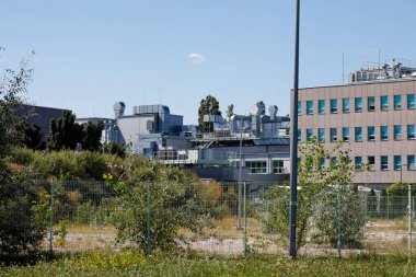 Warsaw, Poland - September 2, 2022: Behind the fence there are buildings that are part of a research and industrial institution located in the Goclaw estate in the Praga Poludnie district