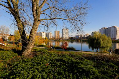 Varşova, Polonya - 6 Kasım 2022: Praga Poludnie bölgesinde geniş bir parka ve oldukça büyük bir göle bitişik çok katlı binalar.