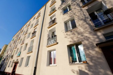 Warsaw, Poland - November 8, 2022: The sunlit facade of a five-story residential building seen in the Wola distric
