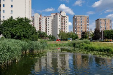 Warsaw, Poland - July 7, 2022: Overall view of the multi-storey residential buildings by the park and lake in the Goclaw estate, in the Praga Poludnie district.