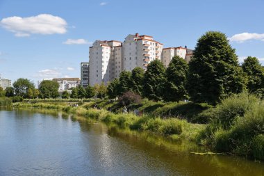 Warsaw, Poland - August 7, 2022: Overall view of multi-storey residential buildings by a park and a lake in the Goclaw housing estate, in the Praga Poludnie district.