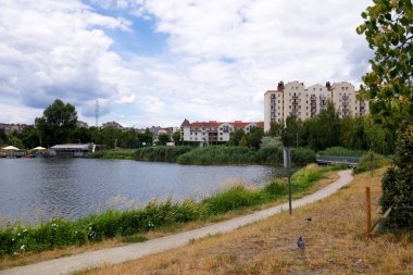 Warsaw, Poland - July 7, 2022: Overall view of multi-storey residential buildings by a park and a lake in the Goclaw housing estate, in the Praga Poludnie district.