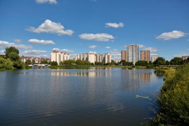 Warsaw, Poland - August 7, 2022: Overall view of multi-storey residential buildings by a park and a lake in the Goclaw housing estate, in the Praga Poludnie district.