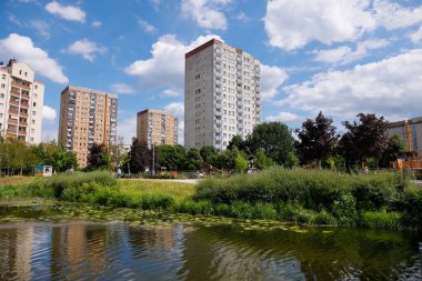 Warsaw, Poland - July 7, 2022: Overall view of multi-storey residential buildings by a park and a lake in the Goclaw housing estate, in the Praga Poludnie district