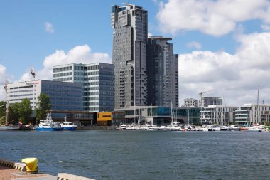 Gdynia, Poland - May 27, 2022: A bit further there are modern buildings that can be seen beyond the waters of the Gulf of Gdansk, in the Gdynia port.