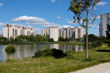Warsaw, Poland - August 7, 2022: Overall view of multi-storey residential buildings by a park and a lake in the Goclaw housing estate, in the Praga Poludnie district