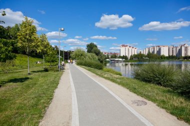 Warsaw, Poland - August 7, 2022: Overall view of the Goclaw housing estate, in the Praga Poludnie district, with a footpath leading through the park by the lake towards multi-storey building