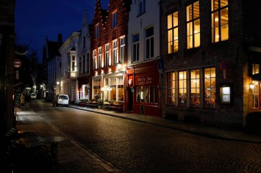 Bruges, Belgium - September 14, 2022: Night in the old town. Architectural details on the buildings are revealed thanks to the artificial lighting of their facades, which can be seen along the street