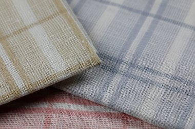 A group of new, unused colored napkins or kitchen towels for daily home use in the kitchen or on a picnic. These little napkins are arranged in a small pil