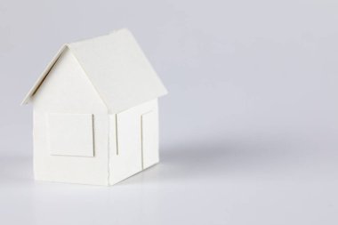 Model of a detached house made of white paper can mean real estate, mortgage or just a paper toy or other real estate meaning