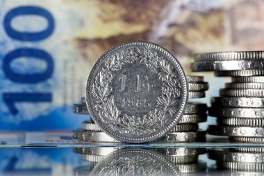The currency of Switzerland is visible here, there are coins, and there is paper money in the background. Swiss franc coins and banknotes can be used as illustrations for many various financial issues