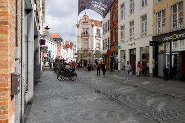 Bruges, Belçika - 8 Eylül 2022: Bu muhteşem ortaçağ kasabasının ve yerel evlerin kaldırım taşı caddesi turistleri cezbeden bir manzara.