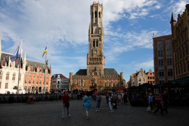 Bruges, Belçika - 12 Eylül 2022: Etkileyici bir ortaçağ binası Belfort van Brugge 'un önündeki büyük bir meydan, Grote işareti buraya gelen çok sayıda turist tarafından ziyaret edildi.