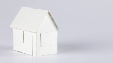Model of a detached house made of white paper can mean real estate, mortgage or just a paper toy or other real estate meaning