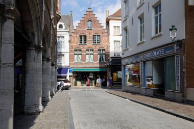 Bruges, Belçika - 11 Eylül 2022 'de kaldırımlı caddelerin kesiştiği yerde tuğladan yapılma bir ev var.