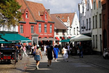 Bruges, Belçika - 11 Eylül 2022: Trafik olmayan ama insanların yürüdüğü kaldırımlı şehir caddesi. Etrafta tuğladan evler var.