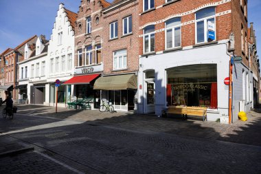 Bruges, Belgium - September 12, 2022: Traditional houses line the street in the old part of this medieval town. There are cobbled streets with little or no traffic and only a few pedestrian