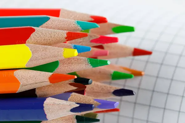 검사받은 포장지의 배경에 색깔있는 연필들이 줄지어 물품들 — 스톡 사진