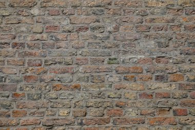 Tuğladan yapılmış bir duvar parçası. Duvardaki tahviller tuğlalar arasında görülebiliyor ve tuğla katmanlarının arasındaki havan topu ile şekilleniyor..