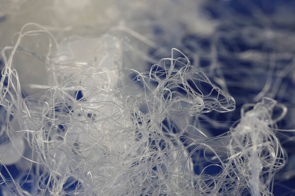 Капли и нити горячего клея уже остыли и видны на темно-синем фоне.