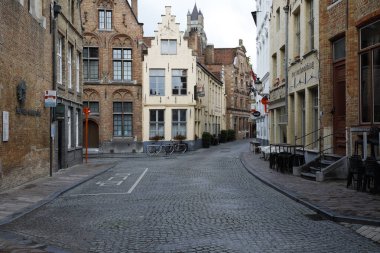 Bruges, Belçika - 9 Eylül 2022: Eski kentteki çok sayıda geleneksel tuğla evin yanındaki dar kaldırımlı cadde kavşağı