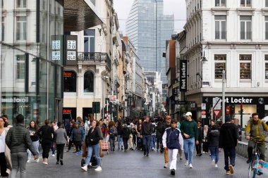 Brussels, Belgium - September 19, 2022: The dense crowd moves in both directions along the Rue Neuve shopping street. There are many shop signs on both sides of the pedestrian zone on the buildings