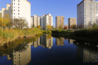 Varşova, Polonya - 6 Kasım 2022: Praga Poludnie bölgesinde geniş bir parka ve oldukça büyük bir göle bitişik çok katlı binalar.