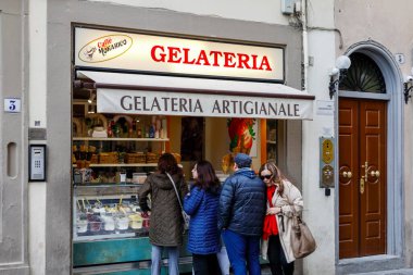 Florence, İtalya - 14 Nisan 2023: İnsanlar dondurmacılarının vitrininin önünde durup dondurmalarını almak ya da sipariş etmek için bekliyorlar