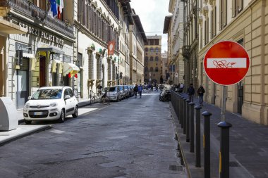 Floransa, İtalya - 15 Nisan 2023: Her iki tarafında büyük binalar olan eski şehrin dar bir caddesi. Bu sokakta çok fazla insan yok.