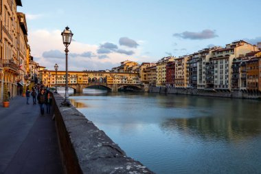 Floransa, İtalya - 13 Nisan 2023: Arno nehrinin iki yakası, her iki tarafında da görülebilir konut binaları var. Biraz ileride tarihi Ponte Vecchio var.