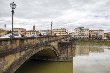 Floransa, İtalya - 14 Nisan 2023: Ponte alla Carraia, Arno Nehri boyunca uzanan kemerli bir köprü ve nehir boyunca evler var.