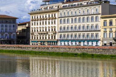 Florence, İtalya - 15 Nisan 2023: Birbirine bitişik iki binada iki otel Arno nehrinin kıyısında yer almaktadır. Nehir boyunca katı bir sel koruması inşa edildi.
