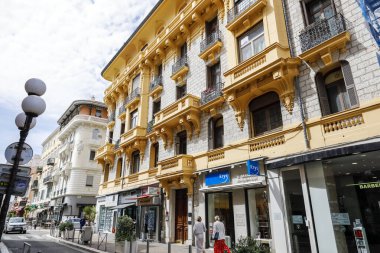 Nice, Fransa - 21 Nisan 2023: Şehir caddesinde birçok dükkan penceresi olan tarihi binalar. Sokak çok dar ve burada fazla trafik yok.
