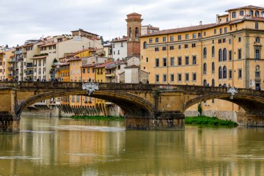Floransa, İtalya - 14 Nisan 2023: Köprünün Ponte Santa Trinita adlı bir bölümü, eski şehrin yerleşim binalarına karşı görünür. Köprüde insanları görebilirsin..