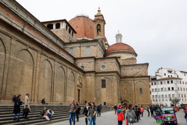 Floransa, İtalya - 13 Nisan 2023: St. Lawrence Bazilikası, şehrin en ünlü kiliselerinden biri. Burası Medici ailesinin üyelerinin gömüldüğü yer. İnsanlar oraya kilisenin yanından yürür.