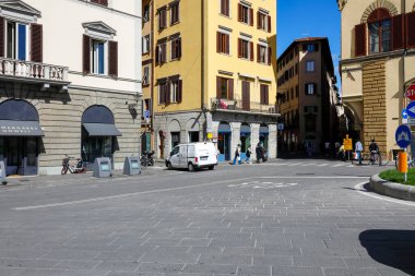Florence, İtalya - 15 Nisan 2023: Caddelerin kesiştiği yer ve civardaki eski kasaba binaları. Bir araba ve birkaç kişi görünüyor.