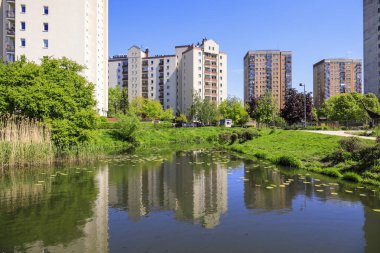 Varşova, Polonya - 9 Mayıs 2023: Göl civarındaki çok katlı binalar ve Praga Poludnie bölgesinde bir kamu parkı görülebilmektedir.