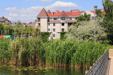 Varşova, Polonya - 29 Mayıs 2023: Praga Poludnie bölgesindeki bir park ve göl ile birlikte ikamet binaları, Goclaw konutları
