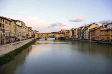 Floransa, İtalya - 13 Nisan 2023: Nehrin her iki yakasındaki binalar ve Arno Nehri boyunca uzanan Ponte Vecchio (Eski Köprü)