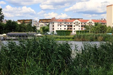 Varşova, Polonya - 21 Temmuz 2023: Praga Poludnie bölgesindeki bir park ve göl ile birlikte ikamet binaları, Goclaw konutları