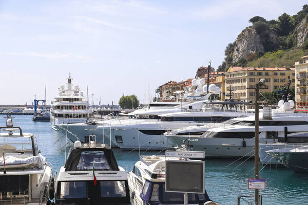 Nice, France - April 23, 2023: Luxury yachts of varying size tied up close together in Port Lympia. Buildings in the city are visible a bit further