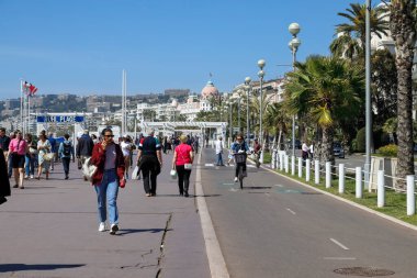 Nice, Fransa - 25 Nisan 2023: Seafront Promenade des Anglais buraya gelen turistler ve sakinler için yürümek, bisiklete binmek ya da rahatlamak için mükemmel bir yer..