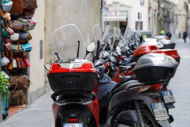 Florence, İtalya - 17 Nisan 2023: Arka arkaya park etmiş birçok scooter sokakta duruyor.