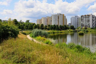 Varşova, Polonya - 21 Temmuz 2023: Praga Poludnie bölgesindeki bir park ve göl ile birlikte ikamet binaları, Goclaw konutları