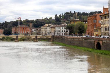 Floransa, İtalya - 14 Nisan 2023: Arno Nehri boyunca görülen şehrin mimarisi ve köprünün orijinal adı Ponte alle Grazie olan bir bölümü