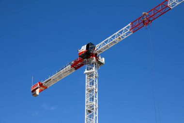 Nice, Fransa - 25 Nisan 2023: İnşaat alanındaki uzun bir vinç parçası güneşli mavi gökyüzüne karşı görünür.
