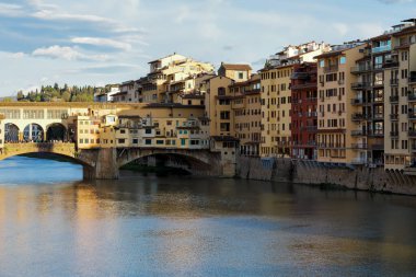 Floransa, İtalya - 16 Nisan 2023: Arno Nehri kıyıları tarafından burada görülen şehir manzarası var. Buradaki binalar yavaşça batan güneşin ışınlarıyla aydınlatılıyor.