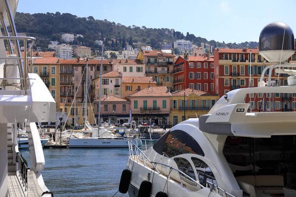 Nice, France - April 23, 2023: The buildings in the city are visible a little further, across the port of Lympia. Yachts moored in the port can also be see
